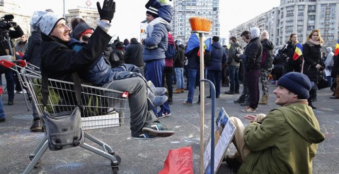 Un padre rumano canta un poema de hip-hop sentado en una canasta de supermercado, junto con su hijo, durante una protesta frente a la sede del gobierno en Bucarest, Rumania, 05 de febrero de 2017. Tras protestas masivas, el gobierno de Rumania anunció hoy