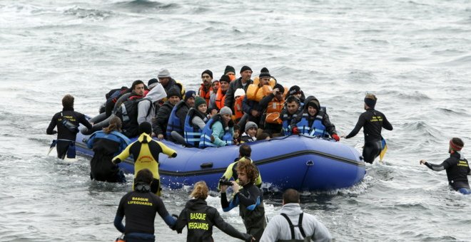 Un grupo de voluntarios acude a rescatar a los refugiados al llegar a la isla de Lesbos. REUTERS