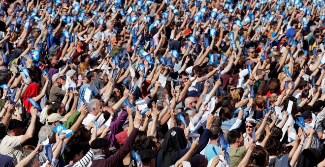 Una multitud de personas sostienen el símbolo de los llamados Artesanos de la Paz, los organizadores del desarme de ETA, en la concentración de Baiona. REUTERS / Regis Duvignau