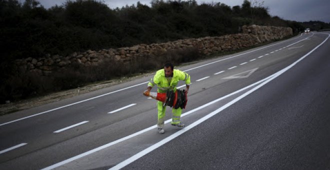 Trabajador colocando conos en una carretera de Ronda, Málaga./REUTERS