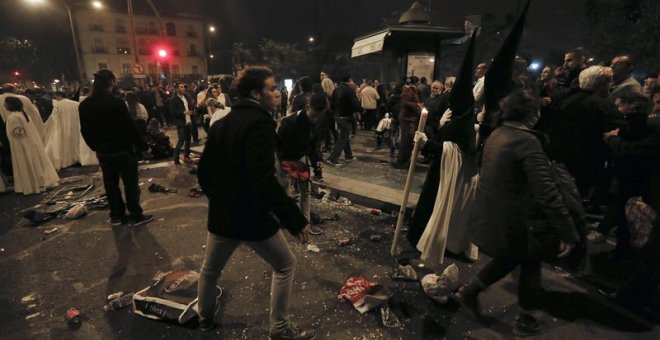 Nazarenos de La Esperanza de Triana ante el descontrol tras sufrir una estampida durante su recorrido procesional a su paso por el puente de Triana, esta noche durante la Madrugá de Sevilla. EFE/José Manuel Vidal