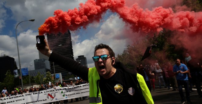 Un conductor de taxi sostiene una bengala durante la protesta contra las empresas de economía colaborativa como Uber, a las que acusan de 'dumping', este miércoles en Madrid. REUTERS/Susana Vera