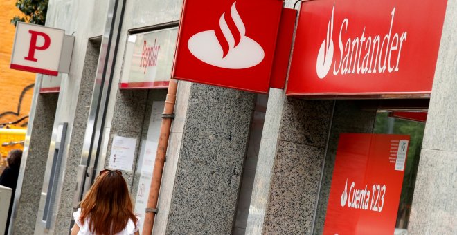 Una mujer pasa por delante de sendas sucursales de Banco Santander y Banco Popular en Barcelona. REUTERS/Albert Gea