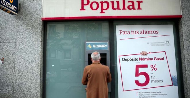 Un hombre retira dinero de un cajero de una sucursal del Banco Popular en Madrid. | EFE