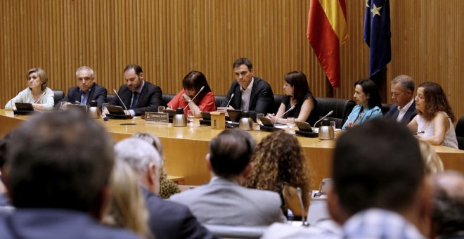 El secretario general del PSOE, Pedro Sánchez, durante su intervención por primera vez ante el grupo parlamentario socialista, con su equipo: la presidenta del partido, Cristina Narbona (4i), Margarita Robles (3d) y el senador burgalés Ander Gil (2d), los