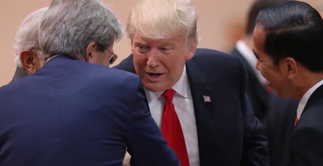 El presidente Trump saluda a otros líderes durante un momento de este sábado.- EFE