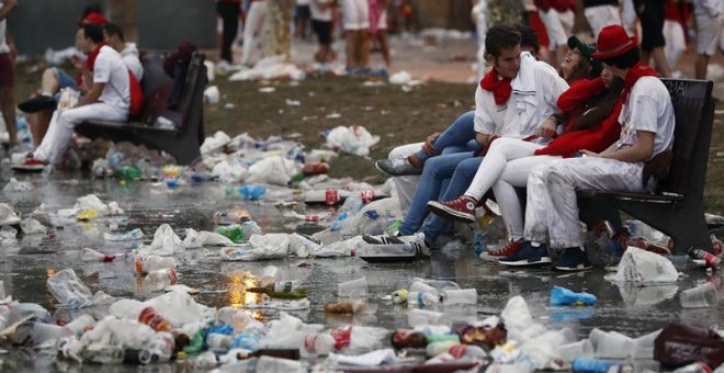 Jóvenes sentados en bancos en la Plaza del Castillo de Pamplona este domingo. /EFE