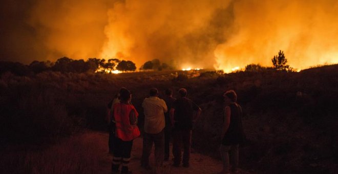 Vecinos de Devesa (Vilardevós) observan el incendio forestal declarado ayer por la tarde en el municipio de Verín que obligó a activar la alerta por "situación 2" por proximidad a núcleos poblados y a cortar carreteras (la N-525 y la A-52). EFE/Brais Lore