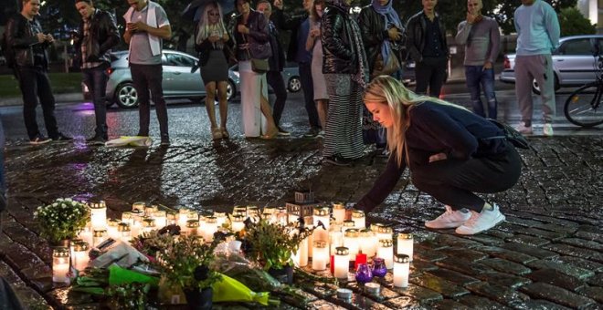 Gente coloca velas en el lugar del ataque. EFE