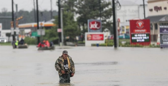 Un hombre camina por una calle inundada después del paso del huracán Harvey en Houston, Texas. - EFE