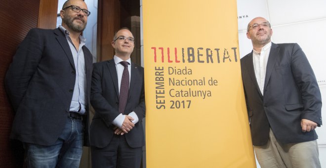 El conseller de la Presidencia y portavoz del Govern, Jordi Turull (c), y el vicepresidente primero del Parlament, Lluís Guinó (d), y el creado artístico del acto de la Diada, Josep María Mestres (i), durante la presentación de los actos institucionales d