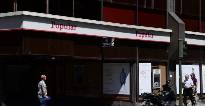 Un hombre pasa junto a una oficina del Banco Popular en  Madrid. AFP/Pierre-Philippe Marcou