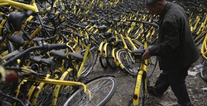 Un mecánico repara una bicicleta de alquiler de la compañía OFO en un depósito que alberga miles de estos vehículos en Pekín (China). EFE/Archivo