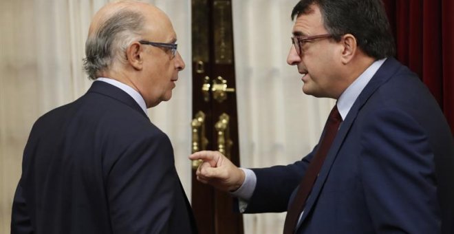 El ministro de Hacienda, Cristóbal Montoro, y el portavoz parlamentario del PNV, Aitor Esteban, dirimen diferencias durante la última sesión de control al Ejecutivo. /EFE