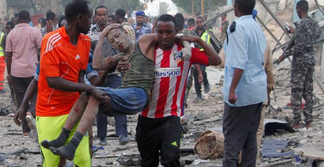 Ciudadanos asisten a un hombre, herido tras la explosión de un coche bomba en Somalia. REUTERS/Feisal Omar