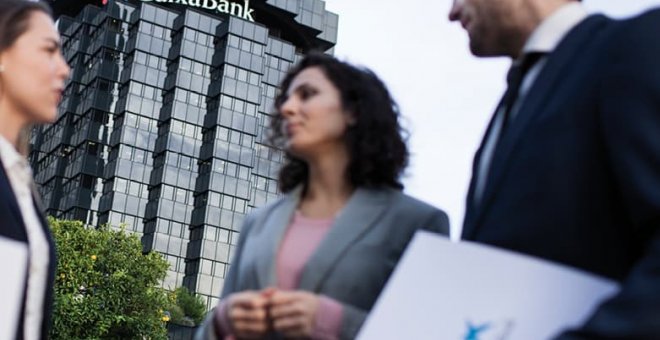 Tres empleados delante de un edificio de CaixaBank.