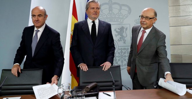 El portavoz del Gobierno, Íñigo Méndez de Vigo (c), junto a los ministros de Economía, Luis de Guindos (i), y de Hacienda, Cristóbal Montoro (d), al inicio de la rueda de prensa posterior a la reunión del Consejo de Ministros en el Palacio de La Moncloa.