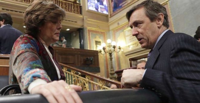 La vicepresidenta del Gobierno, Soraya Sáenz de Santamaría,iz., y el portavoz del Grupo Popular, Rafael Hernando, conversan en el hemicíclo del Congreso. | ZIPI (EFE)