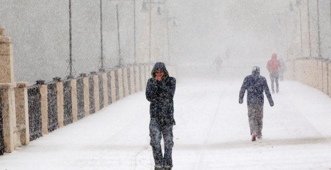 Varias personas entre la nieve en una calle de Teruel. EFE/ Antonio Garcia