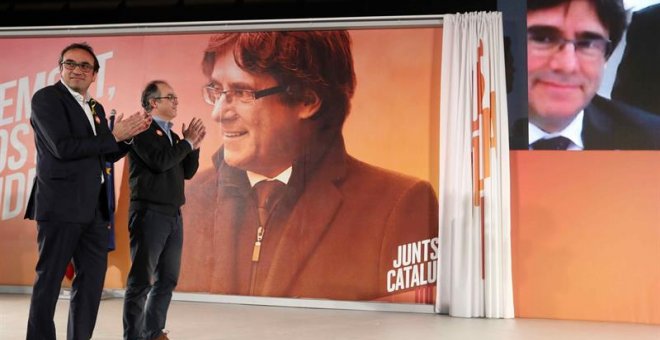 Los exconsellers y candidatos de JxSí Jordi Turull y Josep Rull (i) hablan por videoconferencia con el expresidente Puigdemont durante la rueda de prensa que han ofrecido después de salir de prisión. EFE/Toni Albir