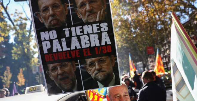 Un manifestante sostiene un cartel crítico con el Gobierno en la última manifestación de taxistas, el pasado 29 de octubre. REUTERS/Juan Medina