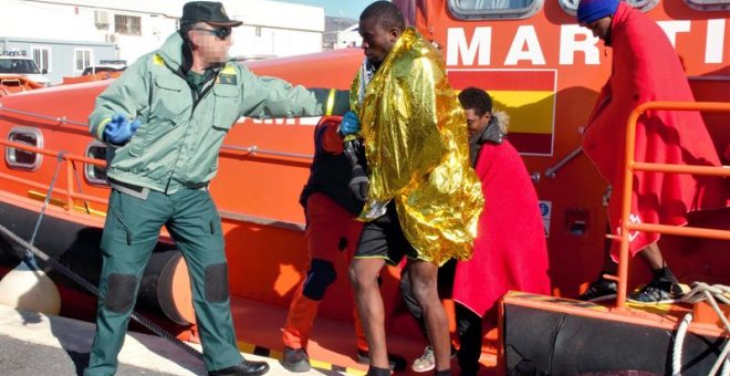 Un agente de la Guardia Civil ayudando a los 36 inmigrantes de origen subsahariano que viajaban en una patera y que han sido rescatados a 11 millas de la isla de Alborán por Salvamento Marítimo. EFE/Alba Feixas