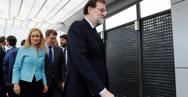 La presidenta de la Comunidad de Madrid, Cristina Cifuentes, tras el jefe del Gobierno y líder del PP, Mariano Rajoy, y junto al presidente de la Xunta de Galicia, Alberto Núñez Feijóo, tras posar para la foto de familia de los barones del PP, en la sede