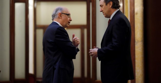 El ministro de Hacienda, Cristobal Montoro, conversa con el portavoz parlamentario del PP, Rafael Hernando, en los pasillos del Congreso, momentos antes del inicio de la sesión de control al Gobierno en el Congreso de los Diputados. EFE/Juan Carlos Hidalg