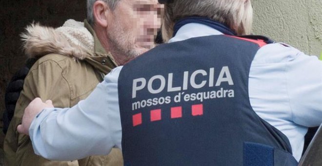 El presunto autor del doble homicidio de Susqueda, Jordi Magentí (i), acompañado de los mosos d'esquadra en el momento de acceder a una casa de Anglès. /EFE