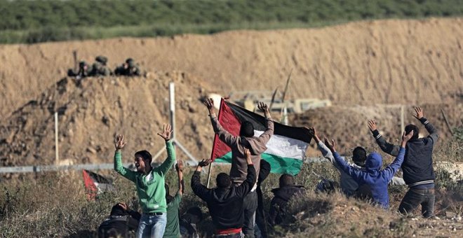 Manifestantes palestinos saludan a los soldados israelíes durante los enfrentamientos con las tropas israelíes a lo largo de la frontera entre Israel y la Franja de Gaza.  EFE / EPA / MOHAMMED SABER