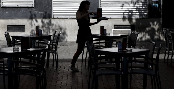 Una mujer atiende una terraza en el centro de Madrid. REUTERS