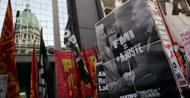 Un manifestante sostiene una pancarta con la imagen del la directora gerente del FMI, Christine Lagarde, y del presidente argentino, Mauricio Macri, en una protesta frente al Congreso, en Buenos Aires. REUTERS/Marcos Brindicci