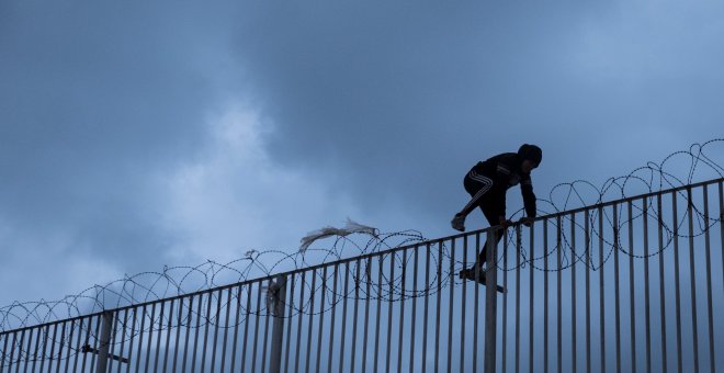 Un menor extranjero salta la alambrada del puerto de Ceuta, donde vive tras escapar del masificado centro de acogida de la ciudad con el objetivo del llegar a la península como polizón en un ferry.- PEDRO ARMESTRE /SAVE THE CHILDREN