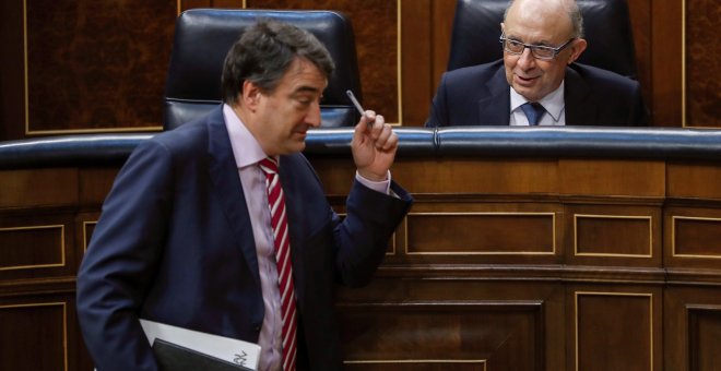 El ministro de Hacienda, Cristóbal Montoro, conversa con el portavoz del PNV, Aitor Esteban, durante el Pleno del Congreso que vota la totalidad del proyecto de Ley de Presupuestos Generales del Estado de 2018. EFE/Emilio Naranjo