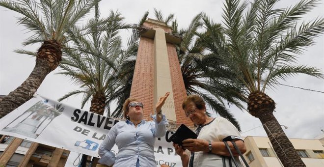 Desde primera hora de la mañana de este martes ciudadanos de La Vall y miembros de la Plataforma Salvemos la Cruz han protestado por las obras de retirada de la cruz que preside la Plaza de España en La Vall d'Uixól. /EFE