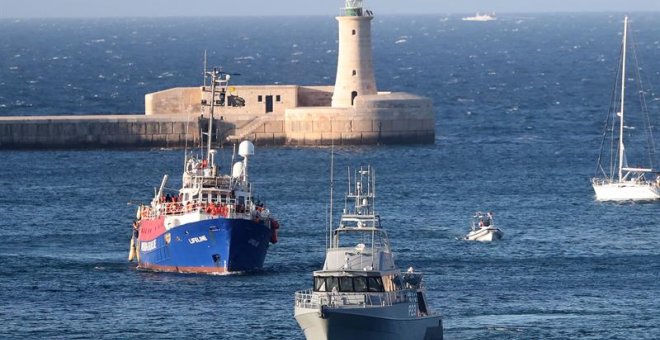 Una embarcación de patrulla de las Fuerzas Armadas de Malta (d) escolta al buque de salvamento de la ONG Lifeline (i) con unos 230 inmigrantes a bordo a su llegada al Gran Puerto de La Valeta (Malta).- EFE/DOMENIC AQUILINA