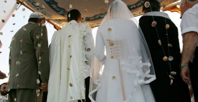 Pareja israelí bajo un altar judío durante su ceremonia de boda en el asentamiento de Neve Dekalim en la Franja de Gaza meridional. AFP PHOTO / DAVID FURST