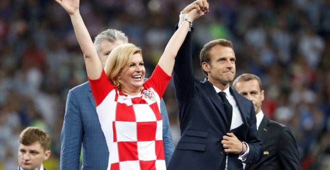 Emmanuel Macron levanta la mano de la presidenta de Croacia Kolinda Grabar-Kitarovic. REUTERS