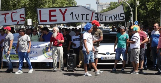 30/07/2018.- Un grupo de taxis permanecen concentrados en el cruce de paseo de la Castellana con Raimundo Fernández Villaverde. La huelga de taxis continúa en la ciudad, que ha dejado sin servicio de este transporte a las estaciones de tren o al aeropuert