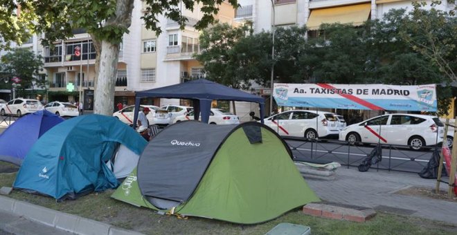 31/07/2018.- Concentración de taxistas en el Paseo de la Castellana, a la altura de Nuevos Ministerios hoy en Madrid. Las asociaciones del taxi Fedetaxi, Antaxi y Élite Taxi han anunciado que mantendrán la huelga que secundan en las principales ciudades e