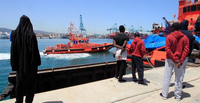 Varios migrantes observan la llegada de una embarcación de Salvamento Marítimo con 19 migrantes rescatados en el estrecho de Gibraltar. EFE/A. Carrasco Ragel