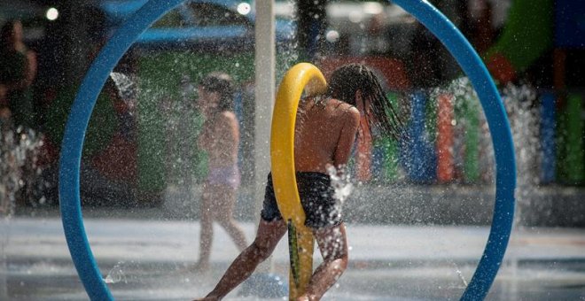 Una niña se refresca en los chorros del parque de la alameda de O Cruceiro en Ourense. / EFE