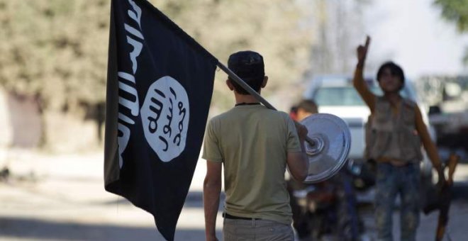 Un chico exhibe la bandera del Estado Islámico por la calle, en una foto de archivo. | EFE