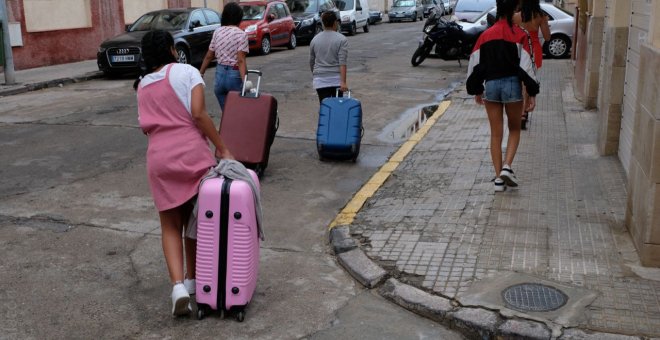 Varias de las menores marroquíes devueltas de Palencia a Melilla cargan con sus maletas en la ciudad autónoma.- JOSÉ PALAZÓN/PRODEIN