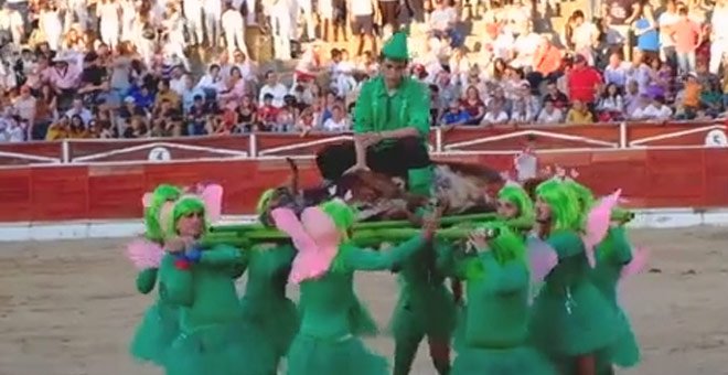 Imagen de la vaquilla muerta retirada por un grupo de jóvenes disfrazados en la plaza de toros de El Espinar. (CAPTURA DE VÍDEO)