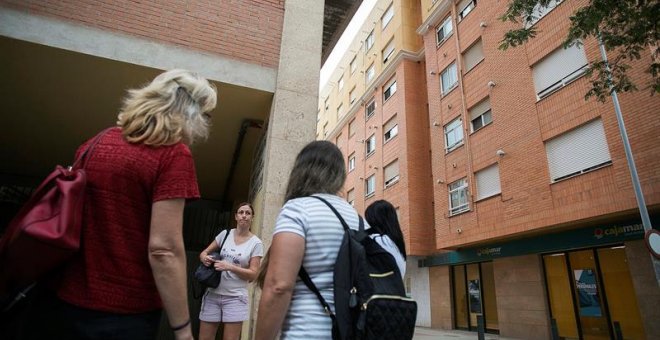 25/09/2018.- Un grupo de vecinos conversa en el lugar donde dos niñas de 2 y 6 años han sido asesinadas a cuchilladas en la ciudad de Castellón supuestamente por su padre, que posteriormente se ha suicidado arrojándose por la ventana de la vivienda, según