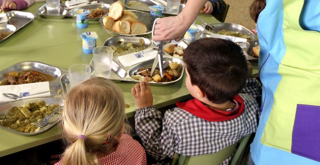 Una madre ayuda a dar de comer a los niños en un colegio público zaragozano. EFE/Javier Cebollada