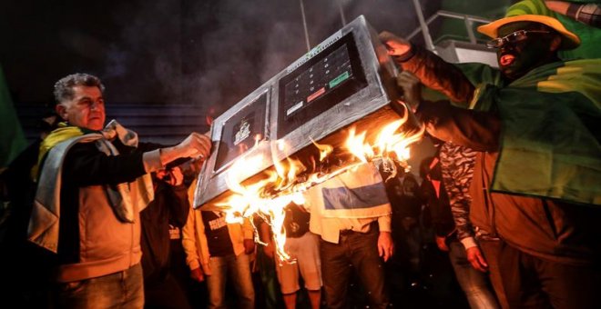 07/10/18.-Simpatizantes del candidato presidencial Jair Bolsonaro del Partido Social Liberal (PSL) se reúnen hoy, domingo 7 de octubre de 2018, y queman una urna electrónica en la avenida Paulista en Sao Paulo (Brasil). El ultraderechista Jair Bolsonaro s