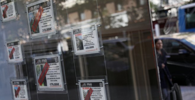 Anuncios de pisos en venta en el escaparate de una oficina inmobiliaria en Madrid. REUTERS/Susana Vera