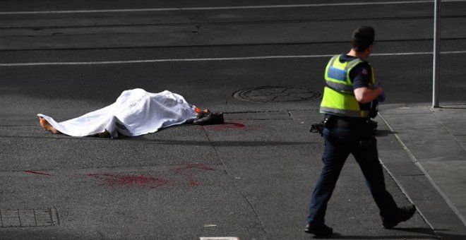 09/11/2018.- El cadáver de una víctima yace sobre el asfalto después de que un hombre armado con un cuchillo atacase a varias personas en la calle Bourke de Melbourne (Australia), hoy, 9 de noviembre de 2018. Una persona murió y otras dos se encuentran ho